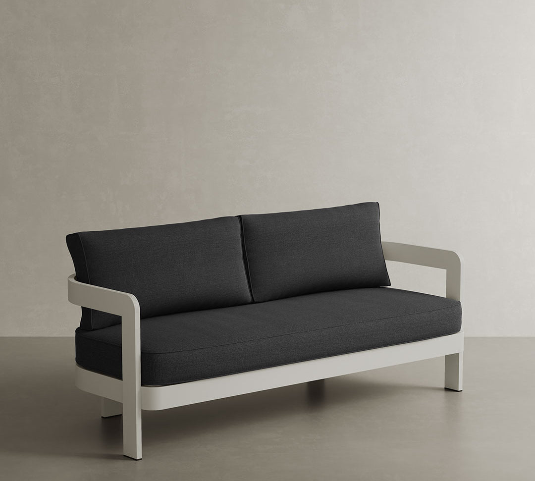 A stylish N3 three-seater sofa in Stone Shadow canvas, featuring a contemporary design with soft, durable fabric. The sofa is supported by a sleek aluminium frame, ensuring both strength and elegance. Its neutral stone colour and modern aesthetic make it a perfect addition to any outdoor space, offering comfort and sophistication.