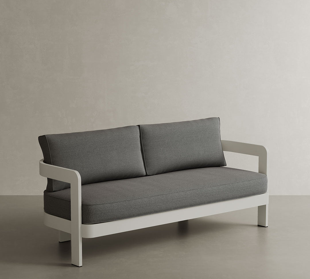 A stylish N3 three-seater sofa in stone smoke weave, featuring a modern design with soft, textured fabric. The sofa is supported by a durable aluminium frame, offering a perfect blend of elegance and strength. Its neutral stone colour and contemporary aesthetic make it an ideal addition to any outdoor space, providing both comfort and sophistication.