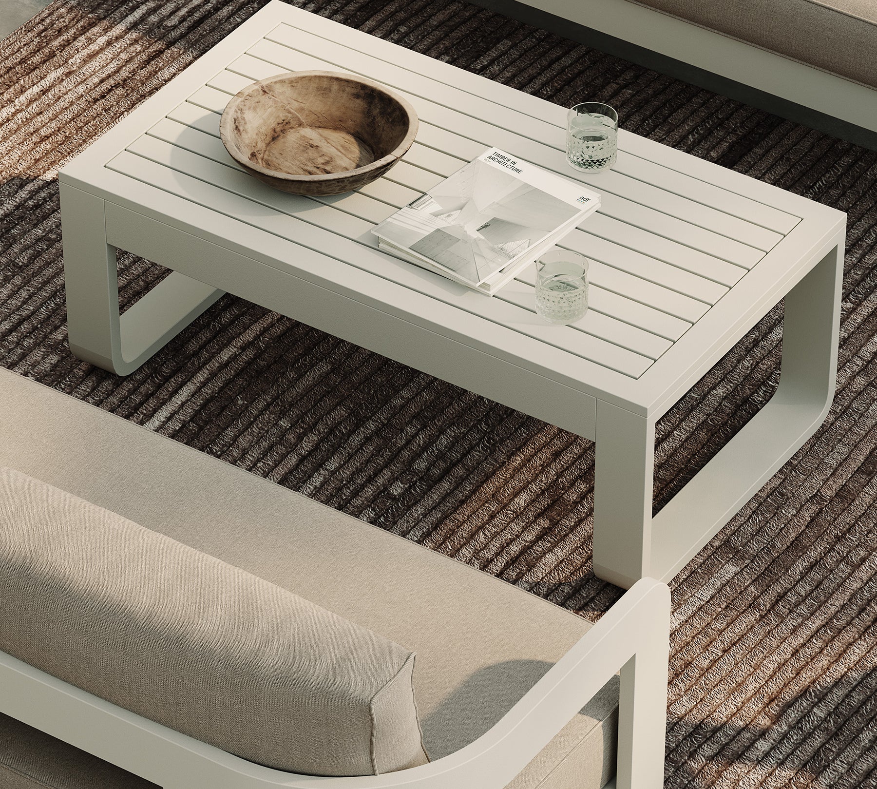 A luxurious stone-coloured outdoor coffee table with a sleek aluminium frame, styled alongside the N3 three-seater sofa in sand canvas fabric and the H1 biscuit rug. The table’s elegant stone finish and modern aluminium frame create a sophisticated focal point, perfectly complemented by the soft, neutral tones of the sofa and rug, forming a refined and inviting outdoor living space.