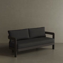 A sophisticated N3 three-seater sofa in Kohl Shadow canvas, featuring a modern design with durable, soft fabric. The sofa is supported by a sturdy aluminium frame, combining sleek style with lasting durability. Its deep, dark colour and contemporary aesthetic make it an ideal focal point for any outdoor space, offering both comfort and a refined, minimalist look.