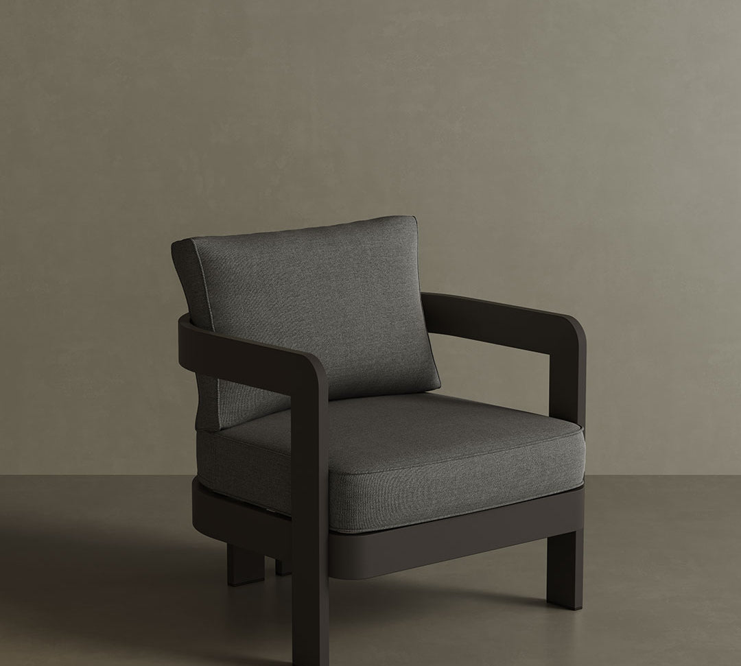 A modern N3 Kohl Smoke Weave lounge chair, featuring soft, durable fabric with a sophisticated smoke weave pattern. The sleek design and sturdy frame offer both comfort and contemporary style, making it an ideal addition to any outdoor or indoor lounge area. Its dark, neutral colour enhances the overall aesthetic, providing a refined and elegant touch.